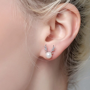 S925 sterling silver reindeer antler pearl stud earrings worn by a model in a side view