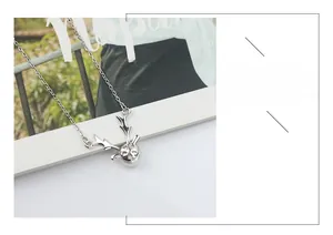 Detail of S925 silver antler necklace with pearl pendant on a fashion magazine background