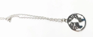 Détail macro du pendentif carte du monde découpé en argent avec chaîne à mailles fines