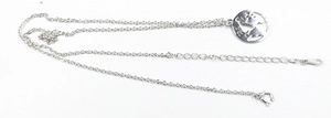 Détail du pendentif mappemonde en argent avec chaîne réglable sur un fond blanc neutre
