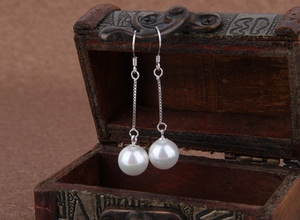 Close-up of elegant 925 sterling silver drop earrings with white natural shell pearls