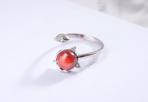 Close-up of red gemstone and fox-shaped silver ring with micro-set zircon detail