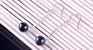 Detail of 925 sterling silver earring with black agate bead and long tassel chain