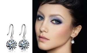 Detail view of round cut zircon crystal drop earrings on model and white background