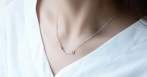 Close-up of S925 sterling silver antler pendant necklace on a female neck for a minimalist look