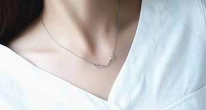 Close-up of S925 sterling silver deer antler pendant necklace worn on a woman's collarbone