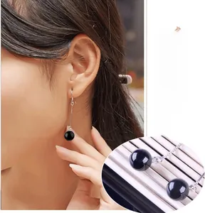Detail of 925 sterling silver drop earrings featuring black onyx beads and long tassels