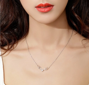 Gros plan du collier en argent S925 avec pendentif bois de renne et cristal scintillant