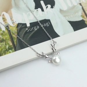 925 Sterling Silver Antler Pendant Necklace with White Freshwater Pearl on Marble Surface