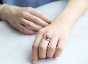 Macro shot of S925 silver fox ring featuring a red gemstone and sparkling diamond accents