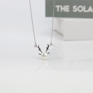 S925 silver elk antler necklace with a freshwater pearl on a glossy white surface