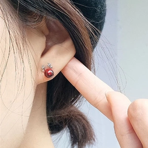 925 silver antler stud earrings with red beads shown on hand for size perspective