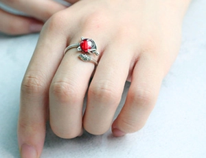 Detail of s925 silver adjustable cat ring featuring a vibrant red round center stone