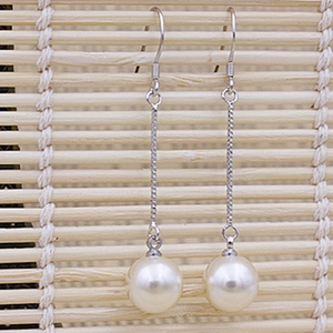 Elegant 925 sterling silver drop earrings featuring natural white pearls on a bamboo mat