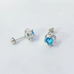 Macro detail of S925 sterling silver four-leaf clover earrings with sky blue gemstone