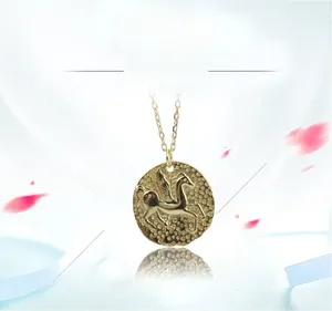 Détail d'un pendentif pièce en argent 925 doré avec relief Pégase et texture martelée