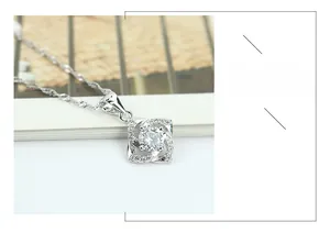 Macro shot of silver four-leaf clover pendant with sparkling zircon and water wave chain