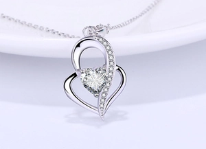 Macro shot of 925 sterling silver double heart necklace with crystal pendant and pavé setting