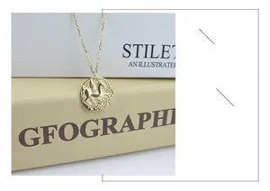 Détail d'un pendentif pièce Pégase doré sur une fine chaîne de collier élégante