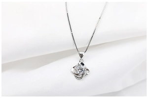 Macro shot of S925 sterling silver necklace with four-petal floral diamond pendant