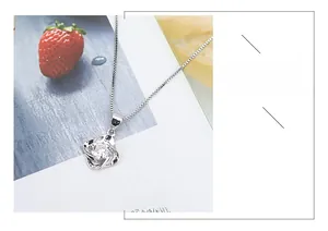 Macro shot of silver S925 necklace with a sparkling cubic zirconia stone on strawberry print