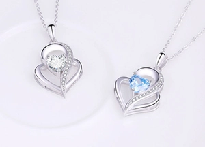 Macro detail of 925 sterling silver hollow double heart pendants with blue and clear stones