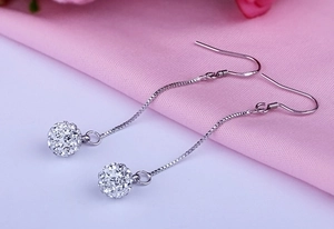 Detail of silver S925 drop earrings with sparkling crystal-studded Shamballa disco balls