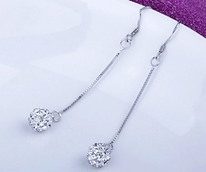 Detail of s925 silver long tassel earrings with shimmering pavé crystal ball pendants