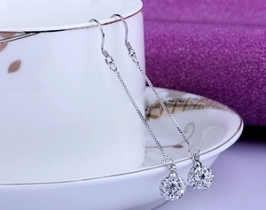 Detail view of s925 sterling silver tassel earrings with crystal pave ball charms