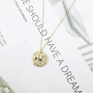 Collier élégant en argent 925 doré avec pendentif pièce relief Pégase sur un magazine