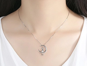 Close-up of S925 sterling silver moon and cat necklace on woman neck