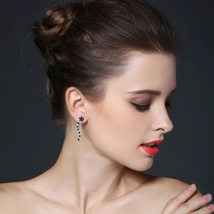 Elegant S925 sterling silver tassel earrings with black floral zircons worn by a model