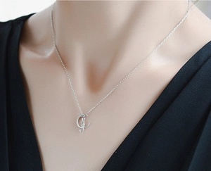 Polished S925 sterling silver moon and cat pendant necklace worn by a female model