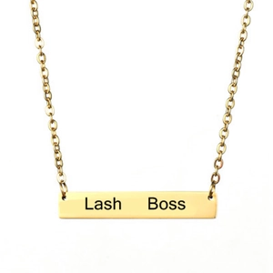 Gros plan détaillé d'un collier barre dorée poli avec gravure Lash Boss gravée