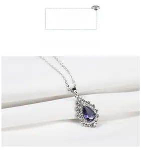 Macro view of pear-cut amethyst pendant with hollow lace silver border and zircons