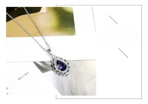 Detailed view of pear-shaped purple amethyst pendant with silver halo setting on necklace