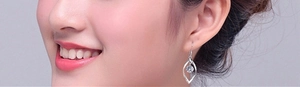 Detail of S925 silver twisted leaf earring with a brilliant round zircon on a model