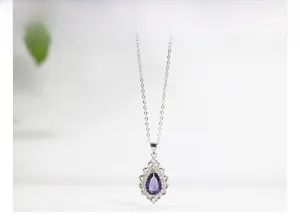Macro view of pear-shaped purple amethyst pendant with diamond-set silver border