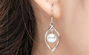 Macro view of S925 sterling silver earring featuring elegant pearl and leaf frame