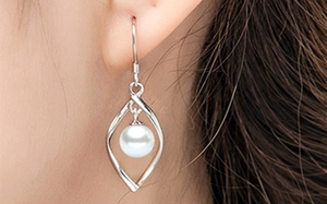 Detail of s925 silver long fringe earrings with pearls on model, elegant tassel design