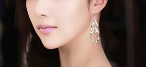 Gros plan de boucles d'oreilles pendantes torsadées en argent S925 portées par un mannequin
