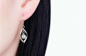 Detail view of s925 silver long tassel pearl earrings with geometric twist design