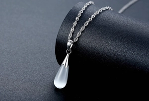 Gros plan du pendentif œil de chat et sa chaîne en argent S925 à maille vaguelette