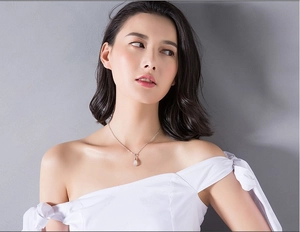 Gros plan d'un collier pendentif goutte en pierre œil de chat sur un mannequin