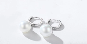 Macro shot of S925 sterling silver stamp on minimalist white pearl hoop earrings