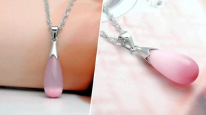 Détail d'un collier avec pendentif goutte en pierre œil de chat rose et chaîne en argent