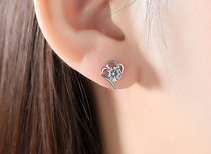 Gros plan sur une boucle d'oreille cœur en argent 925 avec un zircon étincelant