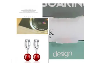 Detail view of S925 sterling silver hoop earrings with round red agate stone charms