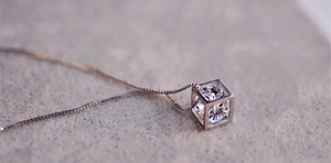 Détail macro de la chaîne box en argent S925 avec pendentif cube et zircon brillant