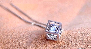 Gros plan du collier en argent avec pendentif cube, zircon brillant et chaîne fine